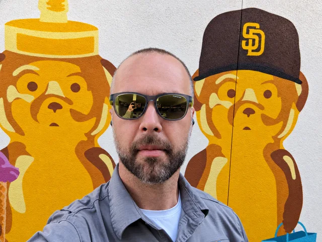 Dima in front of a yellow bear mural.
